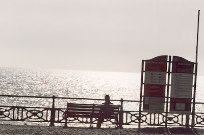 Image of silhouetted man on bench at Hove seatfront, UK