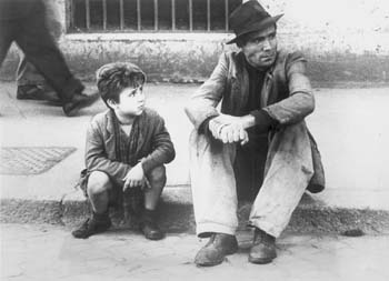 Film still of man and boy sitting on curb
