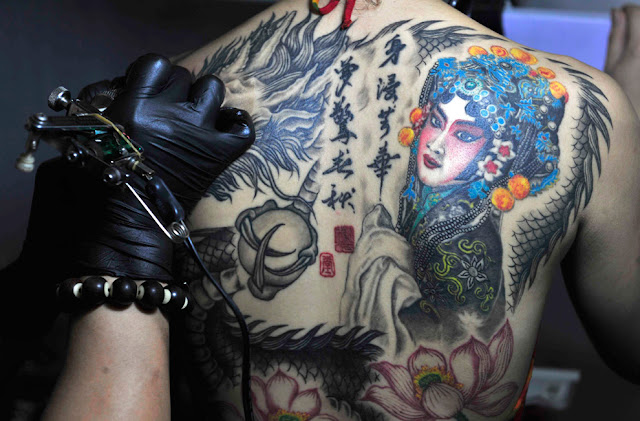 An artist works on a customer at the National Tattoo Competition in Shenyang An artist works on a customer at the National Tattoo Competition in Shenyang