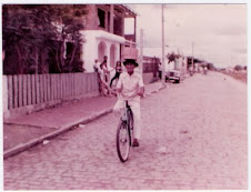 Aurino de bike com um cesto na cabeça.