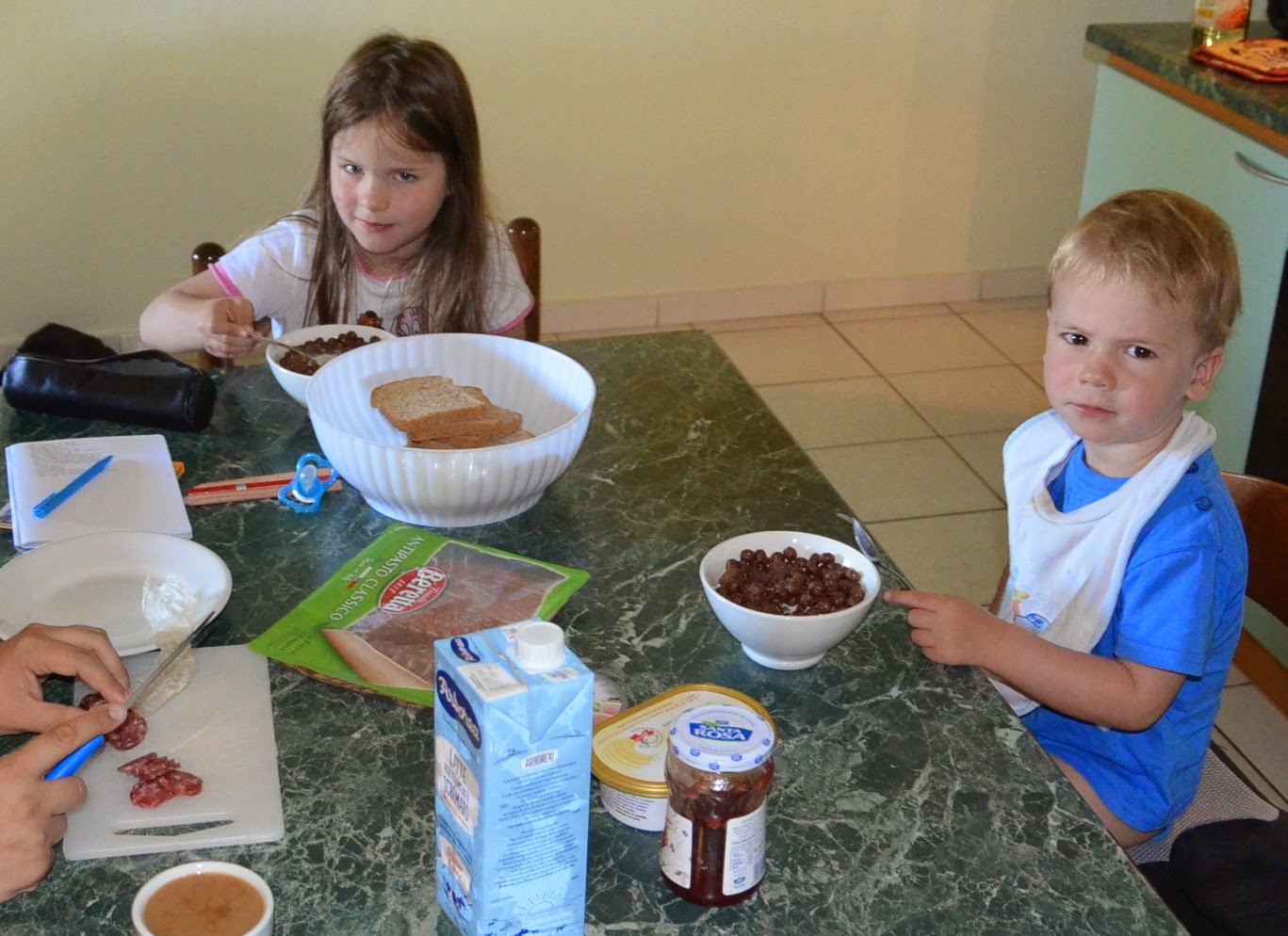 Kinder sitzen am Tisch und frühstücken