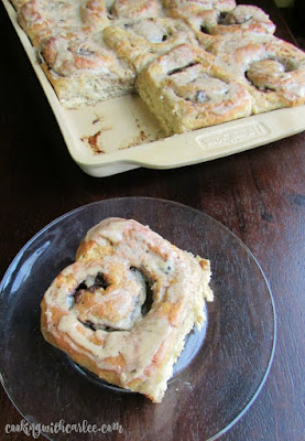 These Coffee and Cream Cinnamon Buns are going to knock your socks off! Breakfast just got better! #SundaySupper coffee cinnamon roll on plate with tray full of buns in the background
