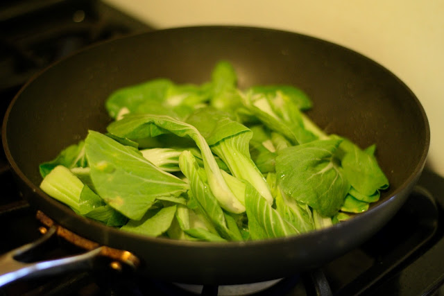 The bok choy in a frying pan. 