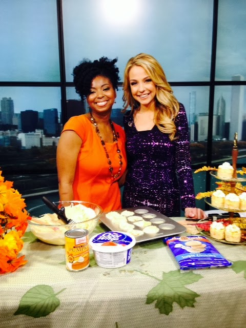 Jocelyn Delk Adams posing with a Fox News anchor and the ingredients to make mini pumpkin cheesecake cookie bites