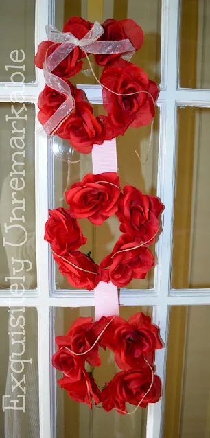 Red rose triple wreath hanging on french door