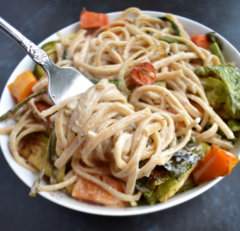 Roasted Vegetable Fettuccine Alfredo is loaded with a garlicky, cheesy creamy sauce with whole-wheat noodles, roasted butternut squash, Brussels sprouts, carrots, onions and asparagus! www.nutritionistreviews.com
