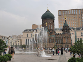 couple taking wedding photos next to the Saint Sophia Cathedral in Harbin