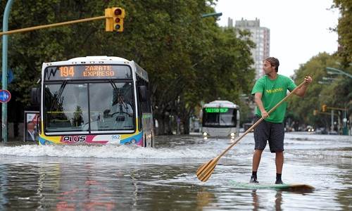A man in a paddleboard in flood water in Buenos Aires, Argentina Flash_flooding_Buenos_Aires