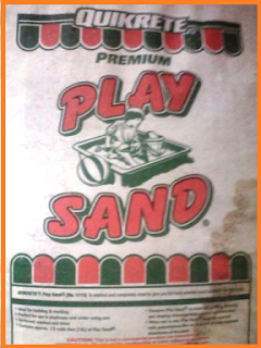 1 old, white bag of play sand with green and red accents.  Water stain off to the lower right side.