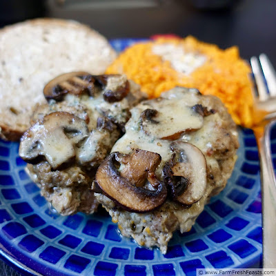 image of a blue plate with 2 slices of mushroom blue cheese meatloaf and sweet potatoes