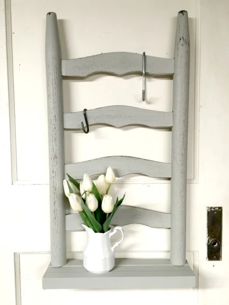 Grey ladder back chair shelf with pitcher of flowers