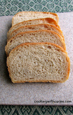 This whole wheat sourdough sandwich bread is great toasted with honey or preserves but also makes a delicious sandwich. It comes together easily and you will love the results! slices of soft sourdough sandwich bread on a cutting board