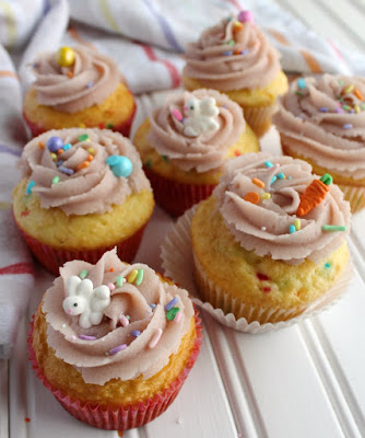 If you are a cookie dough lover, this is for you! It is basically safe to eat sugar cookie dough in frosting form and it's as good as it sounds! sugar cookie dough frosting swirls on cupcakes with cute bunny and carrot sprinkles