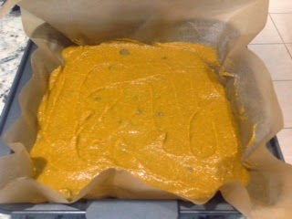 pumpkin pudding bar batter spread in parchment in a baking pan
