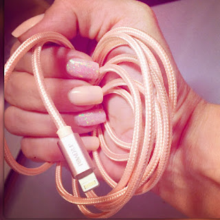 a picture of a well manicured hand holding a rose gold iphone charging cable from #PowerUp