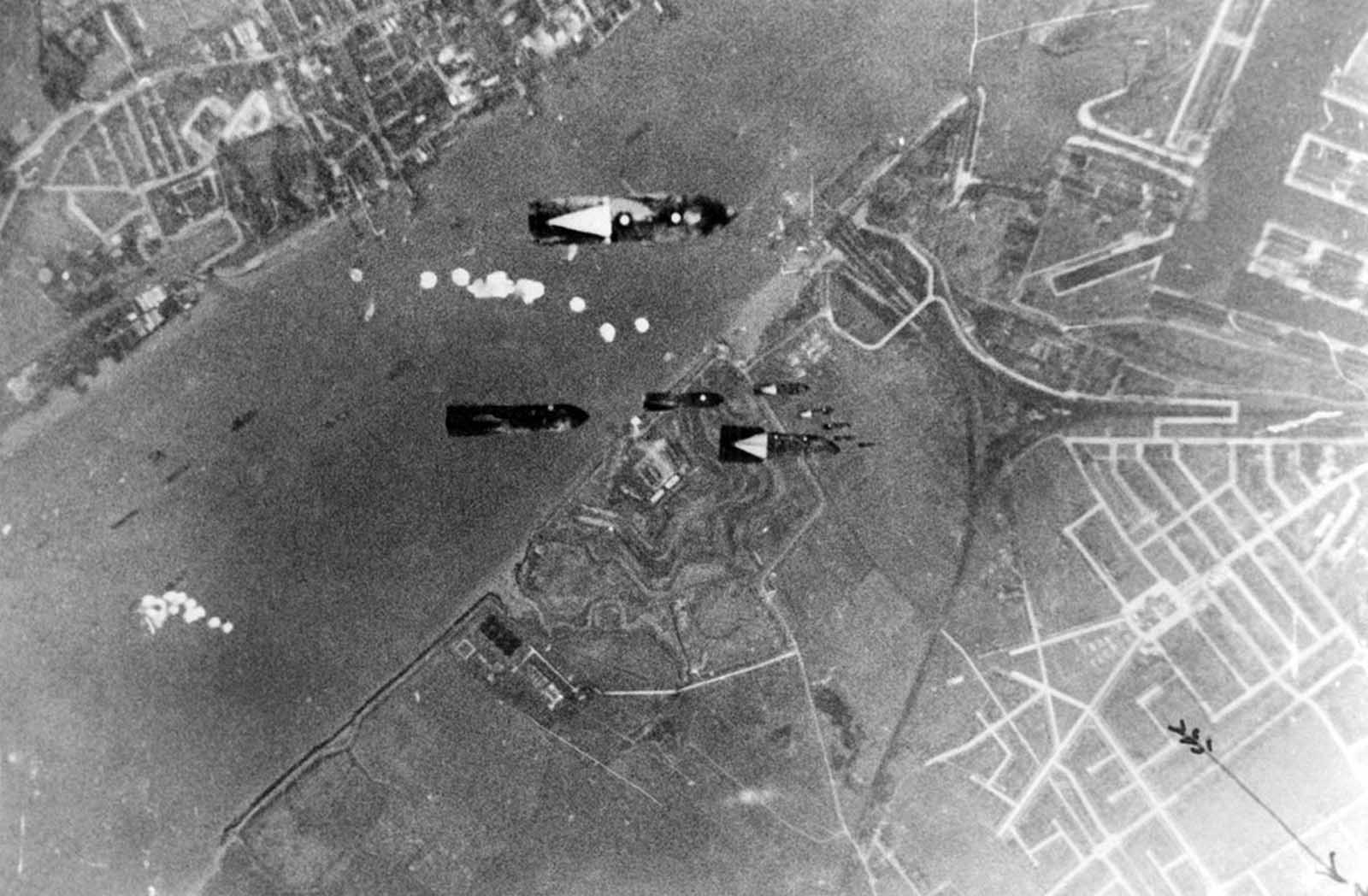 The biggest shipping center for London's food-supplies, Tilbury, has been the target of numerous German air attacks. Bombs dropping on the port of Tilbury, on October 4, 1940. The first group of bombs will hit the ships lying in the Thames, the second will strike the docks.