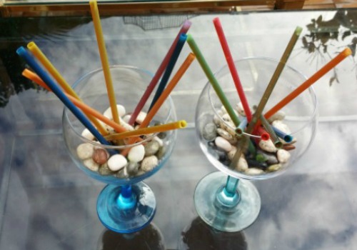 un vaso adornado con piedras y pajitas que dentro tienen gelatina de mojito