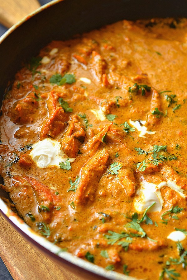 A pan having restaurant style Butter Chicken with cream,and chopped cilantro
