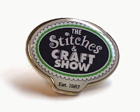 Stitches and Craft Fair enamel badge displays the event logo.