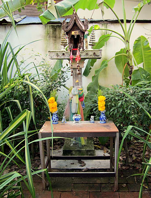 small buddhist shrine with offerings of flowers