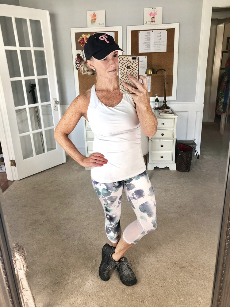 white athletic tank top with floral athletic leggings and nike sneakers