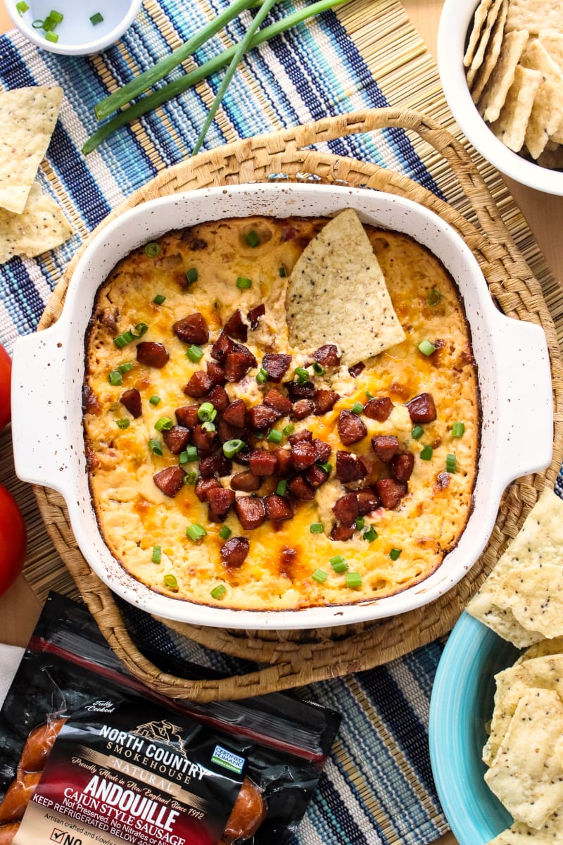 Cheesy Baked Andouille Dip | The Two Bite Club | #northcountrysmokehouse #certifiedhumane #organic #superbowl #ad Cheesy Baked Andouille Dip is not your average sausage dip. It is creamy, super cheesy, easy to make, and full of bold Cajun flavor that will knock your socks off! #northcountrysmokehouse #certifiedhumane #organic #superbowl #ad