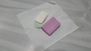 A set of three soap bars placed in a white tissue