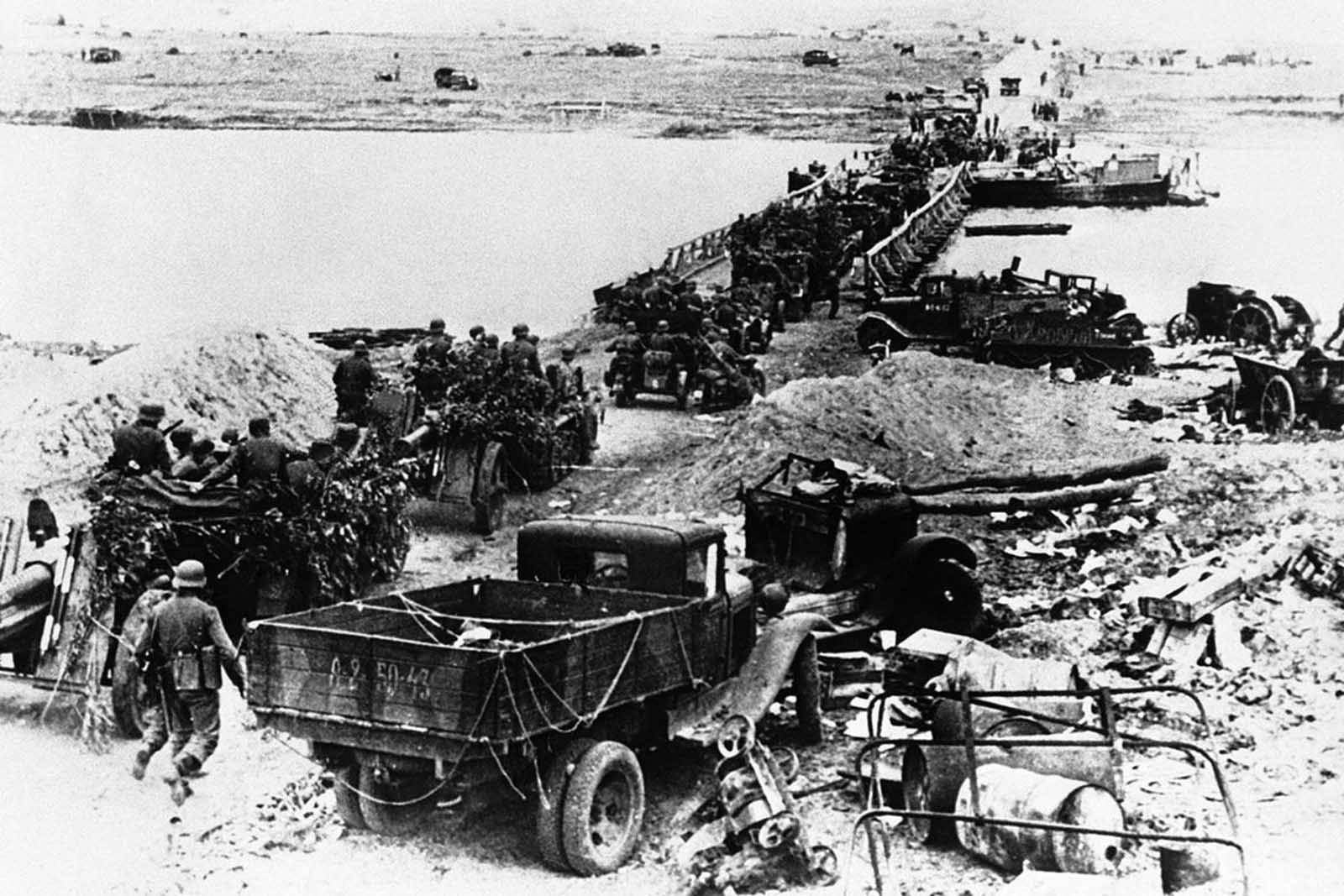 A German motorized artillery column crossing the Don river by means of a pontoon bridge on July 31, 1942. Wrecked equipment and materiel of all kinds lies strewn around as the crossing is made.