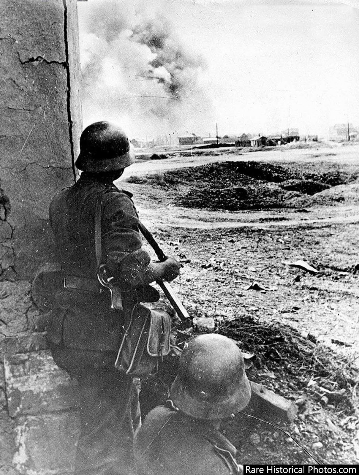 German soldiers watch as German guns pond Stalingrad. 1942.