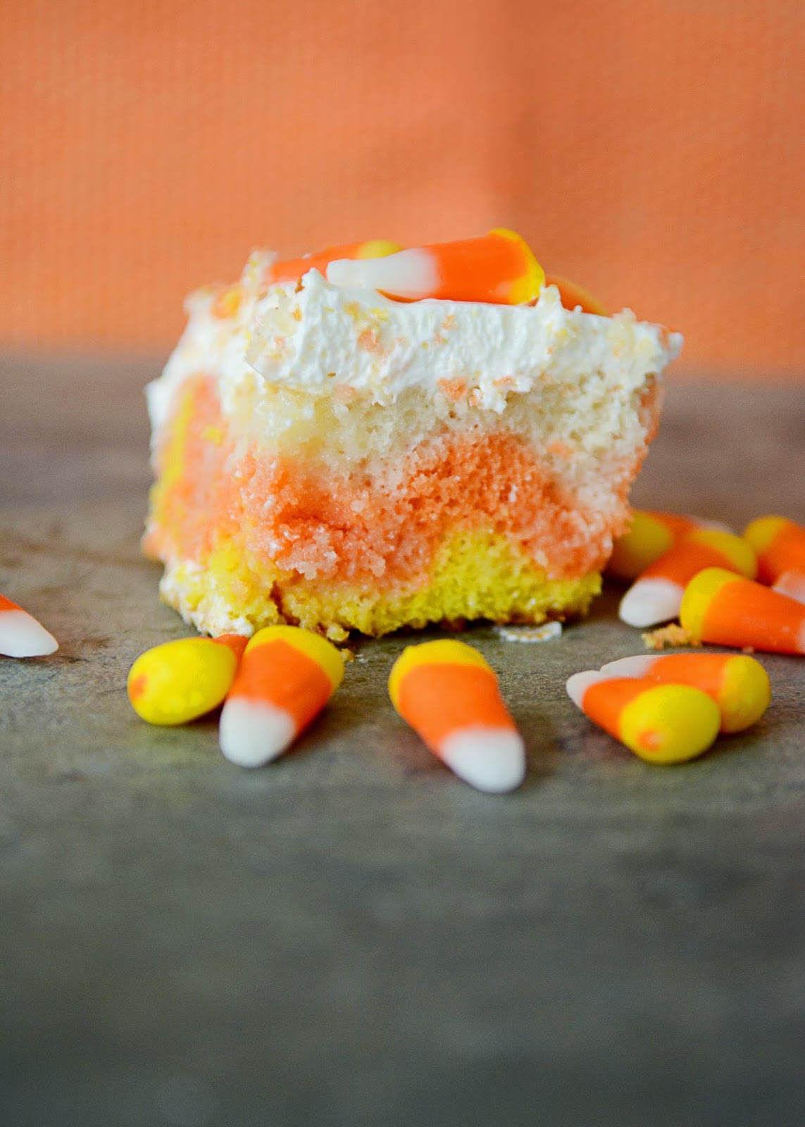 Wow your little goblins this Halloween with this easy to make Candy Corn Poke Cake.  It only takes 5 ingredients and is so simple to make, but everyone will think you worked your tail off creating this masterpiece!