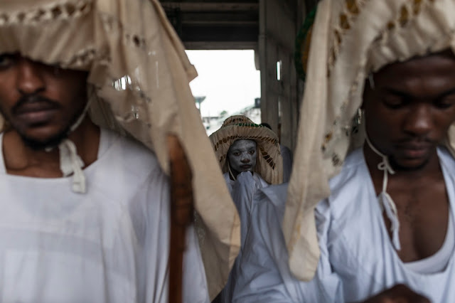 Eyo masqueraders look on as they arrive at the Tafawa Balewa Square in Lagos on May 20, 2017. The white-clad Eyo masquerades represent the spirits of the dead and are referred to in Yoruba as “agogoro Eyo. The origins of the Eyo Festival are found in the inner workings of the secret societies of Lagos where the masquerades ensure safe passage for the spirit of Kings and notable Chiefs into the afterlife. / AFP PHOTO / STEFAN HEUNIS