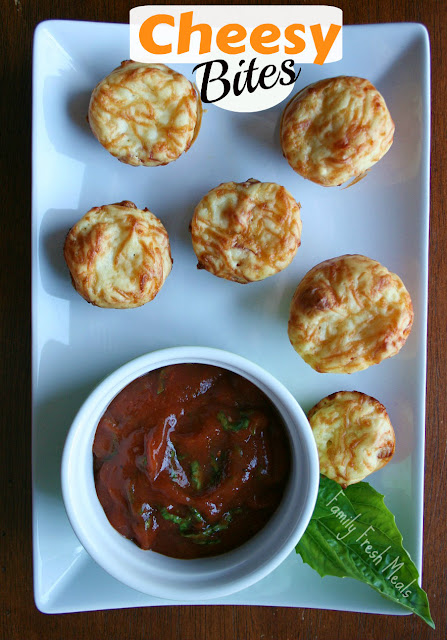 Cheesy Bites served on a white plate, with a cup of dipping sauce