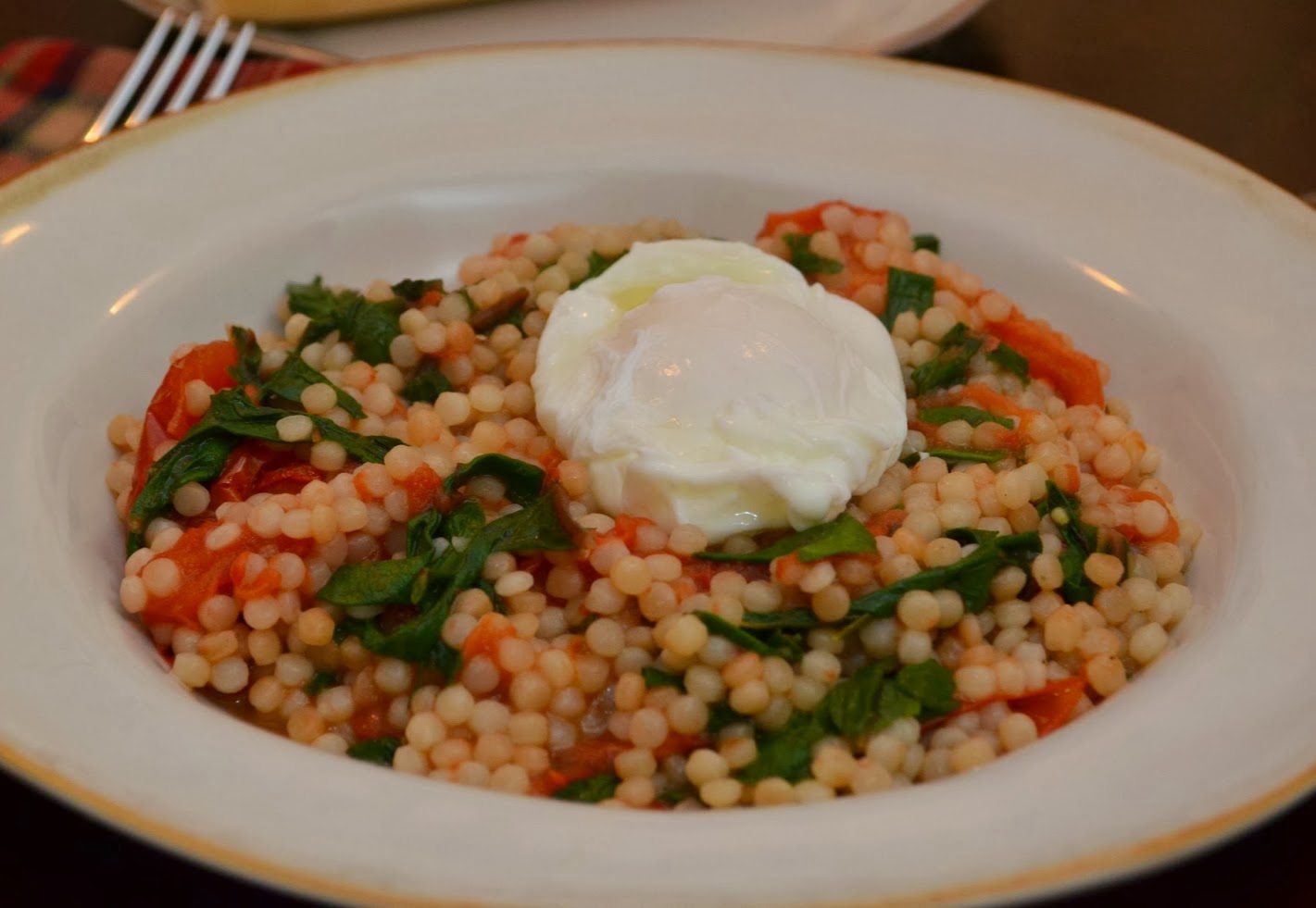 A Texas Belle Israeli Couscous with Roasted Tomato, Swiss Chard, and Poached Eggs