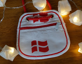 Die Nissedør: Unsere dänische Wichteltür (+ Verlosung). Der Wichtel kann auch Geschenke bringen: Zum Beispiel einen rot-weißen Kinder-Brustbeutel im Dannebrog-Design von Wichtelfee Melanie Berger aus dem fejo Shop.