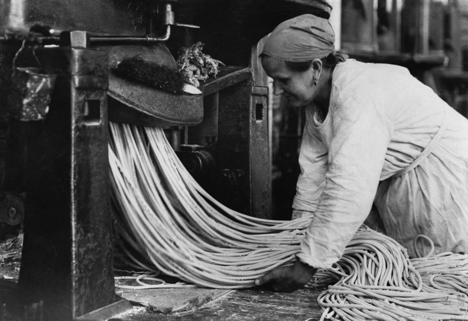 A Russian factory worker handles strands of pasta. Date unknown.