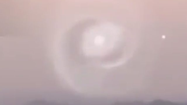 Swirling portal with a UFO or Light Ball coming out of it.