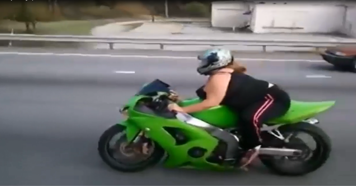 فتاة من وزن تقيل تقود دراجة نارية بمهارة عالية