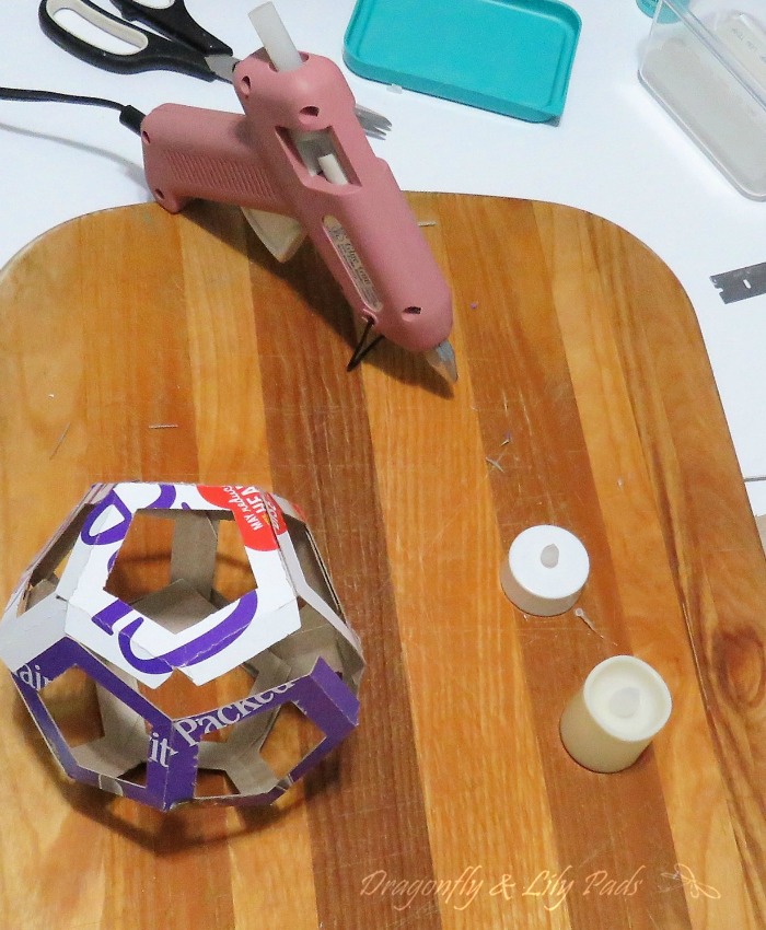 Hot gluing each tab of the Cereal box while creating Dodecagon Votive Candle Holder