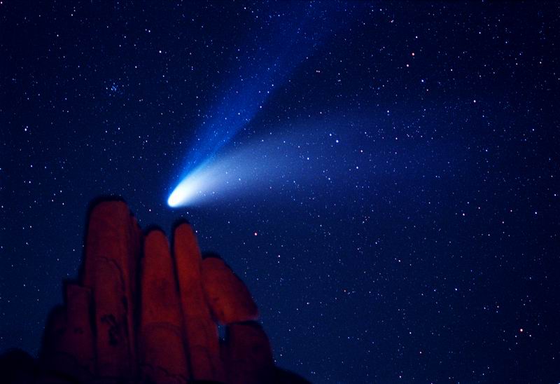 Comet Hale-Bopp over Indian Cove    Comet Hale-Bopp, the Great Comet of 1997, was quite a sight. In this photograph taken on 1997 April 6, Comet Hale-Bopp was imaged from the Indian Cove Campground in the Joshua Tree National Park in California, USA. A flashlight was used to momentarily illuminate foreground rocks in this six minute exposure. An impressive blue ion tail was visible above a sunlight-reflecting white dust tail. Comet Hale-Bopp remained visible to the unaided eye for over a year before returning to the outer Solar System and fading.  Image Credit & Copyright: Wally Pacholka Explanation from: http://apod.nasa.gov/apod/ap131124.html