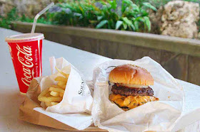Coke, fries and double cheeseburger, picnic table, garden