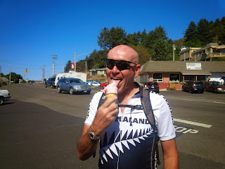 A cyclist enjoying an ice cream in the sun shine.