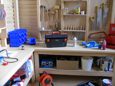 Modern dolls' house miniature shed interior, with tools and storage.