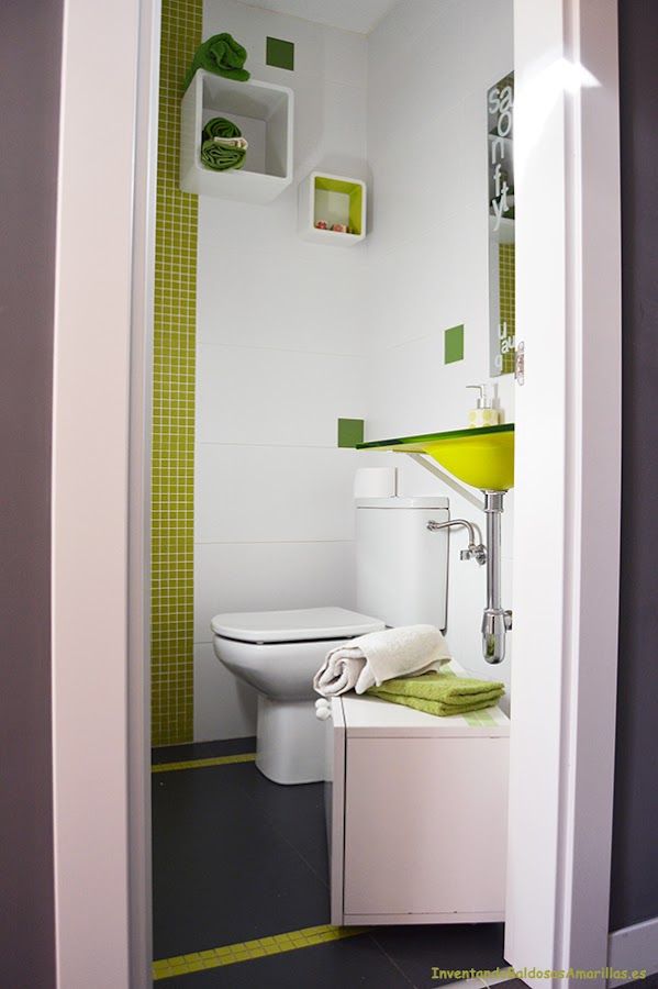 Baño decorado con azulejos y detalles en verde