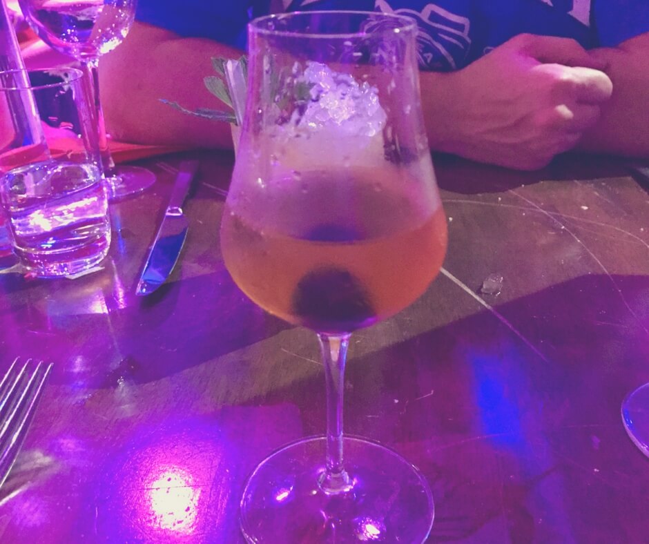 cocktail in a tall glass with a morichino cherry