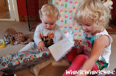 The big toddler helping the birthday boy to open his presents The big toddler helping the birthday boy to open his presents