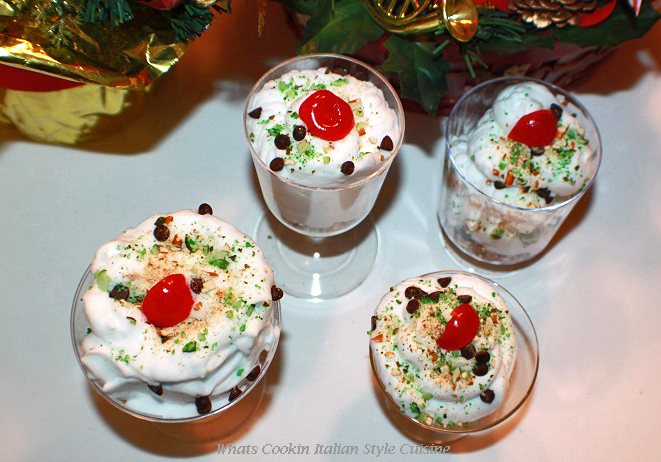 this is how to make a delicious cannoli filling into a mousse dessert. The mousse is layered with crushed cannoli shells topped with cannoli mousse and garnished with mini chocolate chips, crushed pistachios and a cherry on top for a festive christmas no bake dessert.