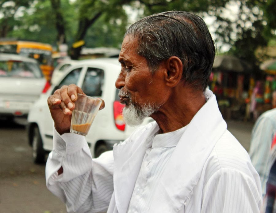 Man drinking chai or tea in a glass