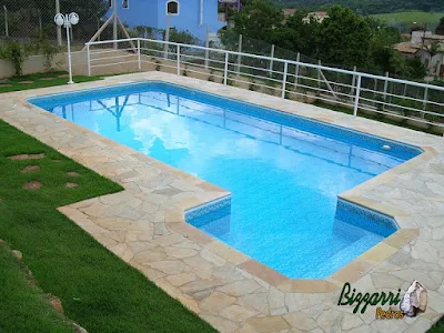Construção da piscina em Itatiba-SP com o revestimento de azulejo, o piso do passeio da piscina com pedra São Tomé tipo caco e o peitoril de alumínio.