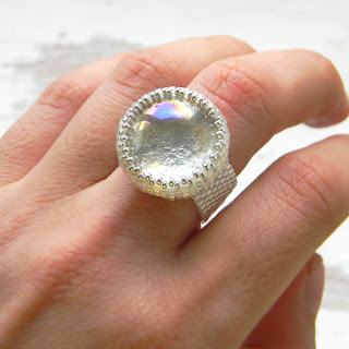 Серебристо-белое сверкающее кольцо со стеклянным кабошоном