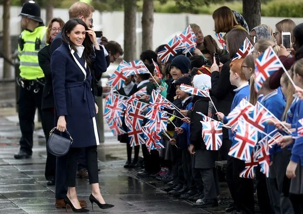 Meghan Markle wore J.Crew coat, Manolo Blahnik pumps, All Saints Ridley jumper, Alexander Wang Pants and carried Altuzarra Ghianda shoulder bag